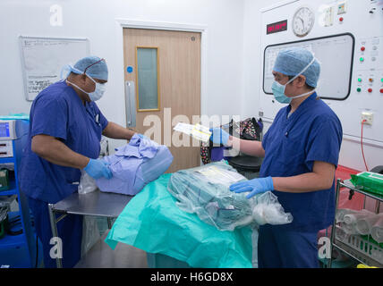 Medizinischem Personal in einem Krankenhaus-OP-Saal während einer Operation Öffnen der sterilen Packungen für Kniegelenkersatz-Operationen Stockfoto