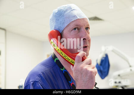 Ein Arzt in einer Krankenstation verwendet das Notruftelefon Ring für Hilfe Stockfoto