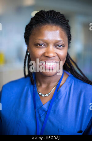 Krankenschwester an einer Workstation in einer Gemeinde, die Beantwortung von Anfragen und medizinische Unterlagen Stockfoto