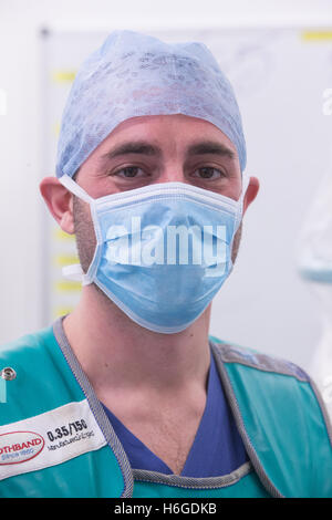Ein X-Ray-Techniker in einer Maske und Anti-Strahlung-Jacke posiert in einem Krankenhaus-Theater Stockfoto