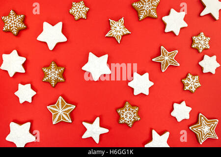 Schneeflocken und Sterne geformt Weihnachten Lebkuchen auf rotem Grund Stockfoto