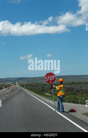 Frau Straßenarbeiter mit Stop-Schild Stockfoto