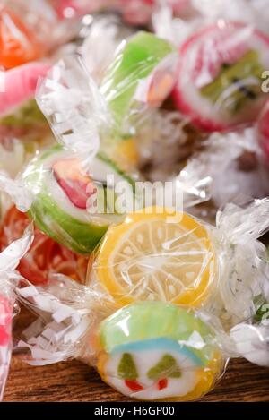 Vertikale Foto mehrere Bonbons mit Fruchtgeschmack und Obst-Motiven mit gelben im Fokus. Jedes Bonbon ist in Zellophan und er Stockfoto