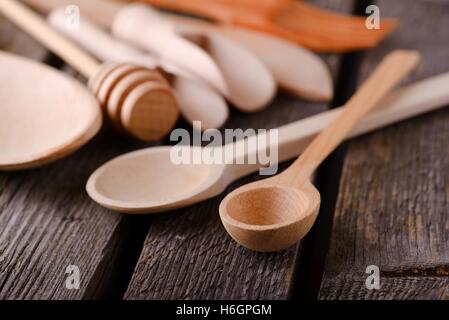 Horizontale Foto von schönen Holzlöffel auf alten grauen Holzbrett mit mehreren hölzernen Dinge und Schalen herum. Stockfoto