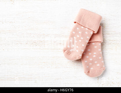 Rosa Baby Socken auf weißem Holz Hintergrund, Ansicht von oben Stockfoto