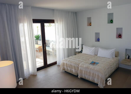 HERAKLION, Kreta, Griechenland - 13. Mai 2014: Innenliegendes Zimmer mit großem Bett, Farbe Lampen und Terrasse in modernen Gebäude des Luxushotels Stockfoto