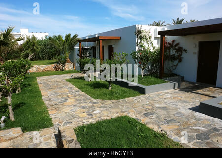 HERAKLION, Kreta, Griechenland - 13. Mai 2014: Blauer Himmel, modernes Gebäude Villa mit Blumen und Palmen am Gelände des Luxushotels. Stockfoto