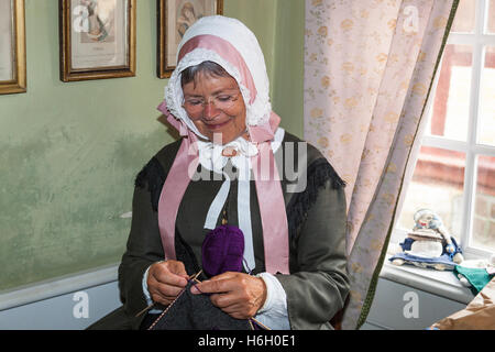 Eine Dame, der Vikar Frau, stricken, Eilschou Armenhäuser, Navnlos Street, Den Gamle By, Aarhus (Dänemark) Stockfoto