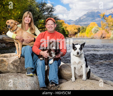 Outdoor-Porträt von Ehepaar mit ihren drei Hunden neben den Arkansas River; Salida; Colorado; USA Stockfoto