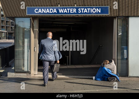 Einen Obdachlosen grobe Schlaf gesehen am Morgen außerhalb Canada Water u-Bahnstation in London, Vereinigtes Königreich. Stockfoto