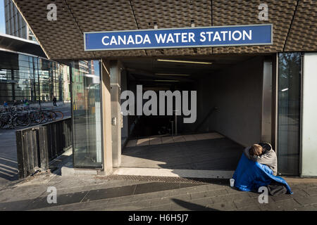 Einen Obdachlosen grobe Schlaf gesehen am Morgen außerhalb Canada Water u-Bahnstation in London, Vereinigtes Königreich. Stockfoto