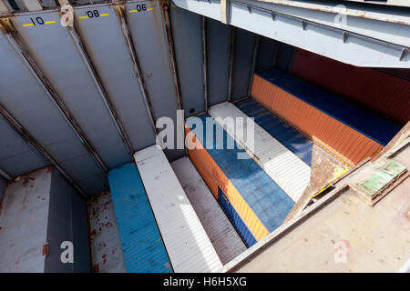 Blick auf einem Frachter Schiff Ablagefach, halbvoll mit Containern, in der Mitte des Ladevorgangs. Stockfoto