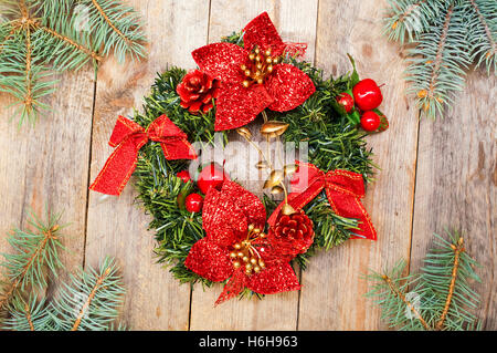 Weihnachtskranz aus Tannenzweigen mit Bögen und Blumenschmuck Stockfoto