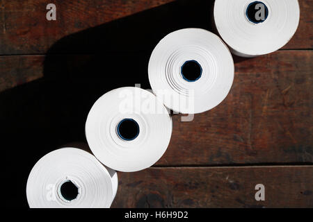 Set von weißem Papier Rollen in einer Reihe auf dunklem Hintergrund Stockfoto