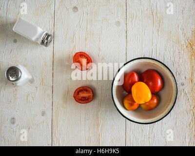 Tomaten und Salz- und Pfefferstreuer auf Holztisch Stockfoto