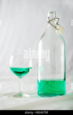 Ein Glas und Flasche Absinth setzen auf weißem Hintergrund Stockfoto