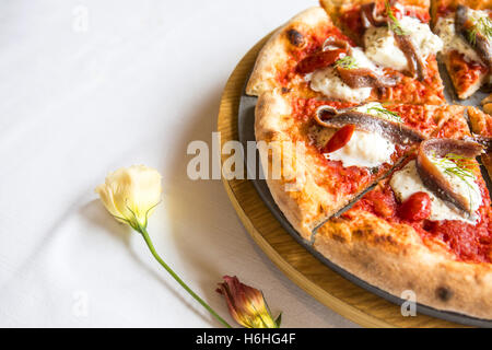 Rustikale italienische Pizza auf weißem Hintergrund. Stockfoto