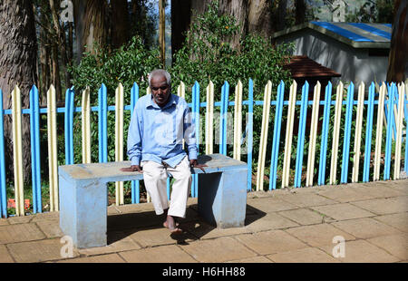 Hohe Alter Senior Mann warten einsam in Railway Station Tamil Nadu, Indien Stockfoto