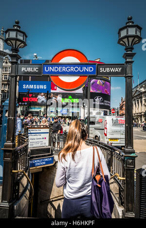 Eine junge Frau wartet draußen Piccadilly-u-Bahnstation in central London, UK Stockfoto