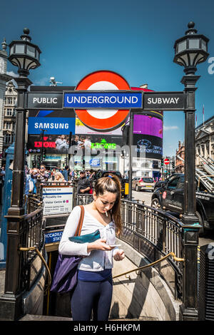 Eine junge Frau wartet draußen Piccadilly-u-Bahnstation in central London, UK Stockfoto