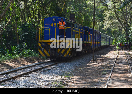 PeruRail Züge tragende Touristen von und nach Cusco verläuft entlang dem Wanderweg in Aguas Calientes am Fuße des Machu Picchu. Stockfoto