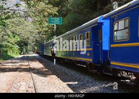 PeruRail Züge tragende Touristen von und nach Cusco verläuft entlang dem Wanderweg in Aguas Calientes am Fuße des Machu Picchu. Stockfoto