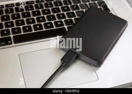 Externe Festplatte über Laptop-Tastatur. Stockfoto