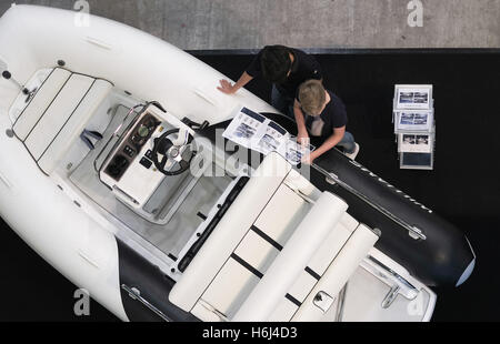 Hamburg, Deutschland. 29. Oktober 2016. Besucher betrachten Broschüren auf der Hanseboot Messe in Hamburg, Deutschland, 29. Oktober 2016. Die Internationale Bootsmesse Hanseboot findet vom 29. Oktober bis 6. November 2016. Foto: AXEL HEIMKEN/Dpa/Alamy Live News Stockfoto