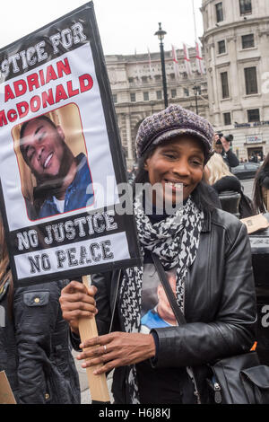 London, UK. 29. Oktober 2016. Eine Frau hält ein Plakat fordert Gerechtigkeit für Adrian McDonald, am 22. Dezember 2014 starb nachdem er Tasered von der Polizei auf einer Party, die er besuchte.  Den Familien und Freunden der Toten von der Polizei oder in den Gefängnissen warten für den Start ihrer jährlichen März in funereal Tempo vom Trafalgar Square zu Downing St zu halten eine Kundgebung und einen Brief an Theresa May. Peter Marshall/Alamy Live-Nachrichten Stockfoto