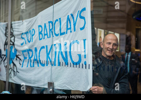 London, UK. 29. Oktober 2016. Ein Anti-Fracking-Kämpferin hält einen Banner innerhalb der Piccadilly Circus-Zweig der Barclays Bank bei einem Protest rund um ein Thema dar,"die Auswirkungen der Fracking-Haus" aufgrund des Engagements der Bank durch seine Investitionen in die dritte Energie in Fracking in Ryedale, North Yorkshire. Stockfoto