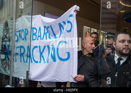 London, UK. 29. Oktober 2016. Ein Anti-Fracking-Kämpferin hält einen Banner innerhalb der Piccadilly Circus-Zweig der Barclays Bank bei einem Protest rund um ein Thema dar,"die Auswirkungen der Fracking-Haus" aufgrund des Engagements der Bank durch seine Investitionen in die dritte Energie in Fracking in Ryedale, North Yorkshire. Stockfoto