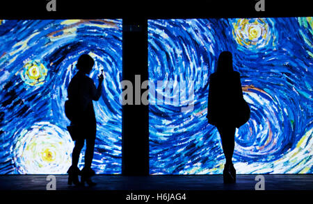 Beijing, Okt. 25. 26. März 2017. Zwei Frauen sehen das Bild des Gemäldes "The Starry Night" auf der "Van Gogh Alive"-Ausstellung in Rom, Italien, 25. Oktober 2016. Die Ausstellung startete am Montag und dauert bis 26. März 2017. Mit 3.000 Bilder, von denen mehr als 800 Gemälde von Vincent Van Gogh lebendig, zeigt die Ausstellung das Leben und die Werke von Vincent Van Gogh 1880-1890 mit dem innovativen video-Technologie. © Jin Yu/Xinhua/Alamy Live-Nachrichten Stockfoto