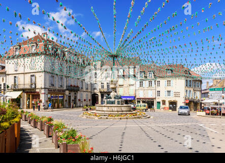 Springbrunnen und die umliegenden Gebäude in Place De La Liberté, geschmückt für eine Fête, Arbois, Jura, Frankreich Stockfoto