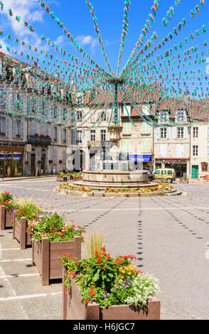 Springbrunnen und die umliegenden Gebäude in Place De La Liberté, geschmückt für eine Fête, Arbois, Jura, Frankreich Stockfoto