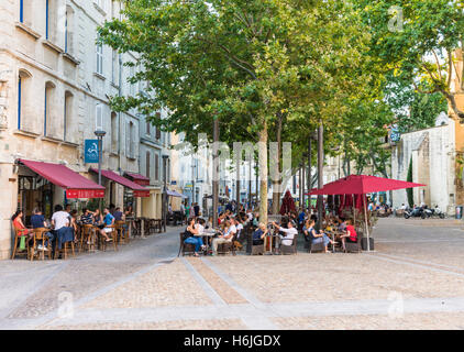 Menschen Essen im Restaurant im Freien Tische in den frühen Abendstunden am Place des Corps Saints, Avignon, Frankreich Stockfoto