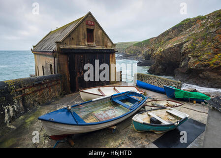 Angelboote/Fischerboote vor der historischen alten Royal National Lifeboat Institution Station Bootshaus am Lizard Point, Cornwall, an der felsigen Südküste Stockfoto