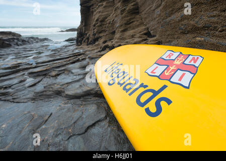 Rescue Board mit Label "Bademeister" von der Royal National Lifeboat Institution stützte sich auf einem Felsen am Trebarwith Strand, Westküste von Cornwall, UK Stockfoto