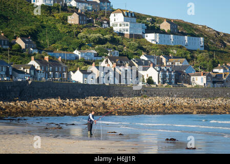 Fischer am Strand von Sennen Cove vor den Häusern der Küstenstadt Sennen in Morgen Sonne, Cornwall, England, Großbritannien Stockfoto