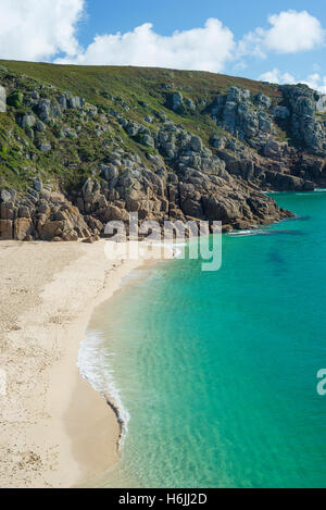 Türkisfarbene Meer am Sandstrand Porthcurno auf Penwith Halbinsel in der Nähe von Minack Theatre mit Klippen an der Küste im Sommer, Cornwall, England, UK Stockfoto