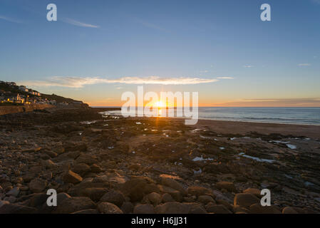 Sonnenuntergang am Atlantischen Ozean und den Kiesstrand Sennen Cove bei Ebbe in der Nähe von Endland im Sommer, Westküste von Cornwall, England, UK Stockfoto