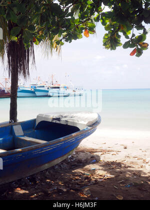 Panga Fischerboot am Ufer Brig Bay Big Corn Island Nicaragua Zentralamerika mit kommerziellen Fischereiflotte im Hintergrund in ha Stockfoto