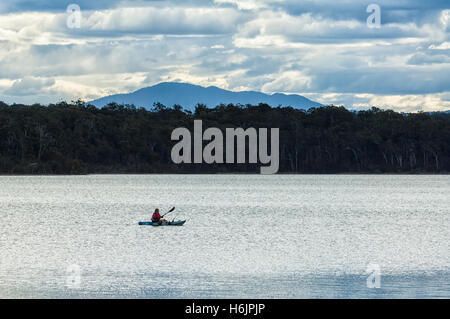 Person, Kajakfahren und Angeln auf Wallaga Lake am Abend, in der Nähe von Bermagui, New South Wales, NSW, Australien Stockfoto