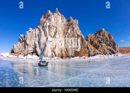 Eis-Schlitten, Ski-Stöcke und Rucksack vor Schamanen Rock am Baikal-See. Stockfoto
