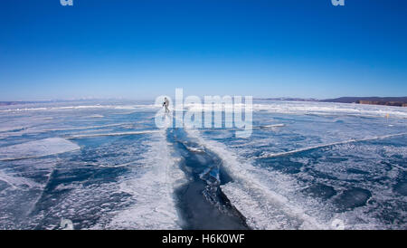 Man geht durch einen großen Spalt in das Eis des Baikalsees. Stockfoto