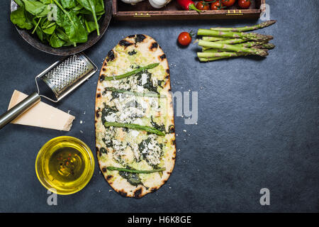 grünen Spargel und Hähnchen Pizza auf Holz befeuerten dünne Kruste Stockfoto