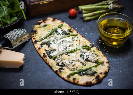 grünen Spargel und Hähnchen Pizza auf Holz befeuerten dünne Kruste Stockfoto