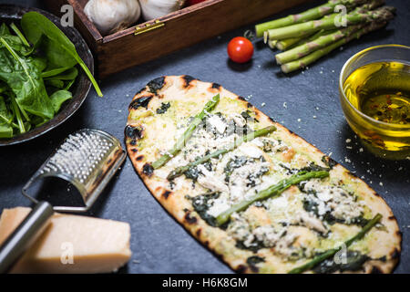 grünen Spargel und Hähnchen Pizza auf Holz befeuerten dünne Kruste Stockfoto