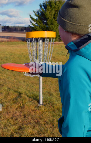 Frau mit dem Ziel Scheibe zum Ziel auf Frisbee-Golf-Kurs Stockfoto