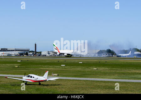 Christchurch, Neuseeland. 31. Oktober 2016. Emirates-Flug EK412 kommt in Christchurch zu wässrig herzlich von der Flughafenfeuerwehr.  Diese ersten Linienflug eines Airbus A380 in nach Christchurch kam aus Dubai und Sydney. Christchurch ist der zweite Flughafen Neuseelands zum Hosten des Super-Jumbo A380 und der Dienst gilt als großartige Neuigkeiten für Canterbury Tourismus und Geschäftsreisende gleichermaßen. Im Vordergrund ein Aero-Club wartet Flugzeuge abheben. Bildnachweis: Ross jüngere/Alamy Live-Nachrichten. Stockfoto