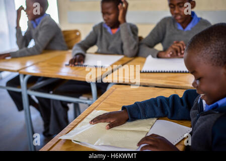 Schülerinnen und Schüler der 4. Klasse für Sehbehinderte visuell Kinder von Eluwa Special School lesen einen Text in Braille-Schrift im naturwissenschaftlichen Unterricht in Ongwediva, Namibia Stockfoto